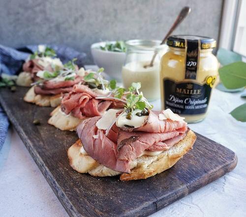 Need a simple yet elegant holiday appetizer? Look no further than this easy to make Roast Beef Crostini, perfect for parties! Roast beef crostini on serving board