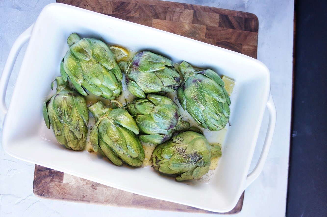 artichokes ready to roast in baking dish