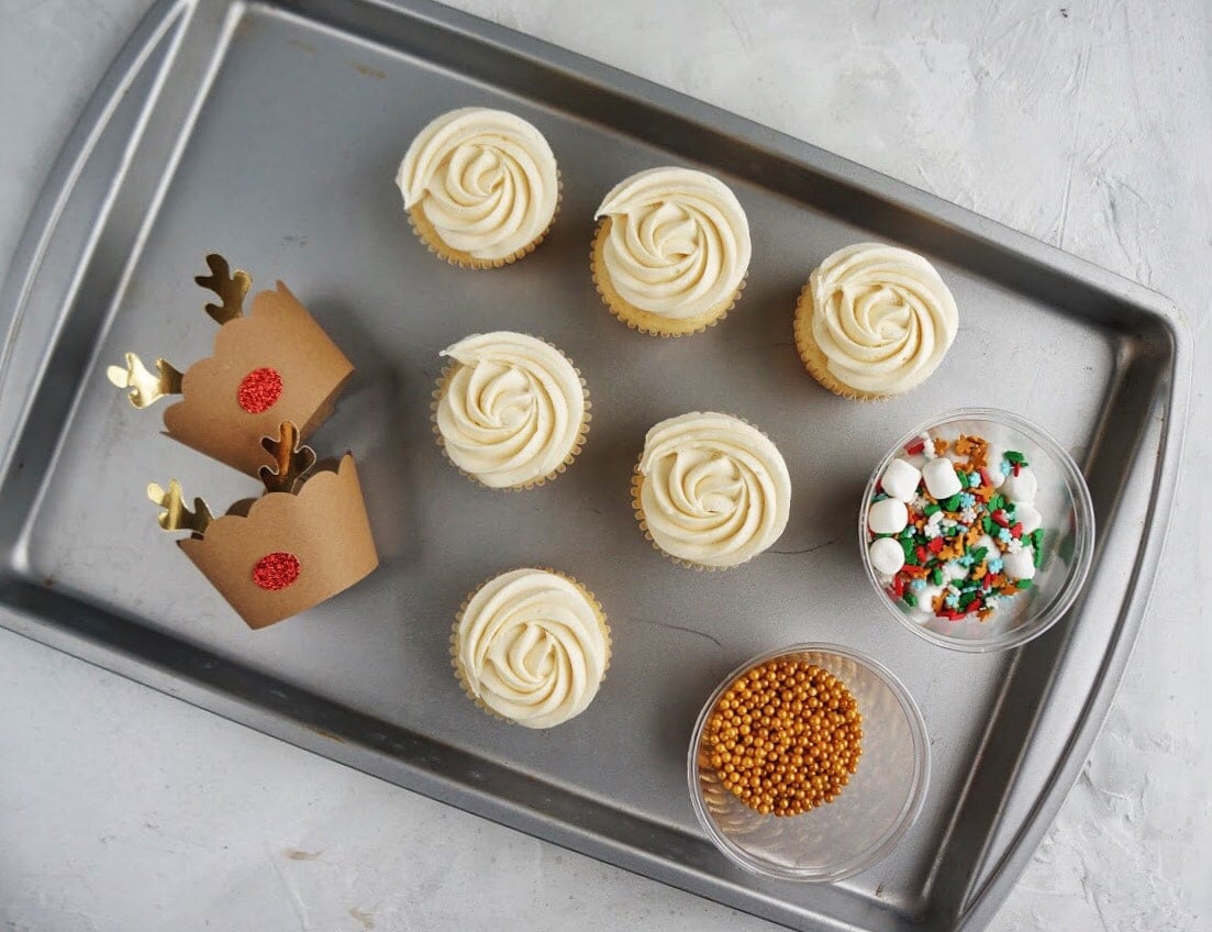 cupcakes frosted with sprinkles in cups