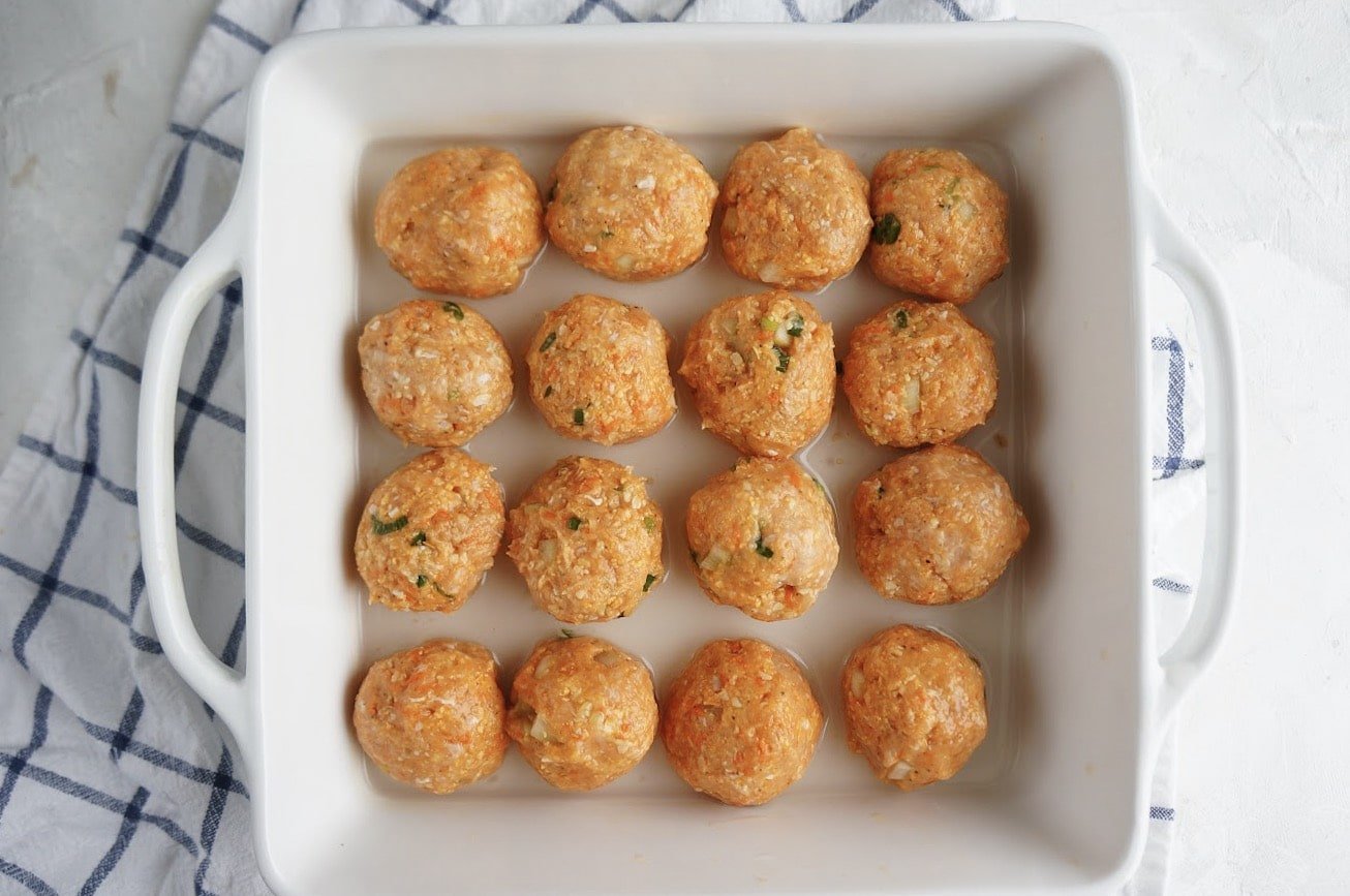 uncooked buffalo chicken meatballs in baking dish 