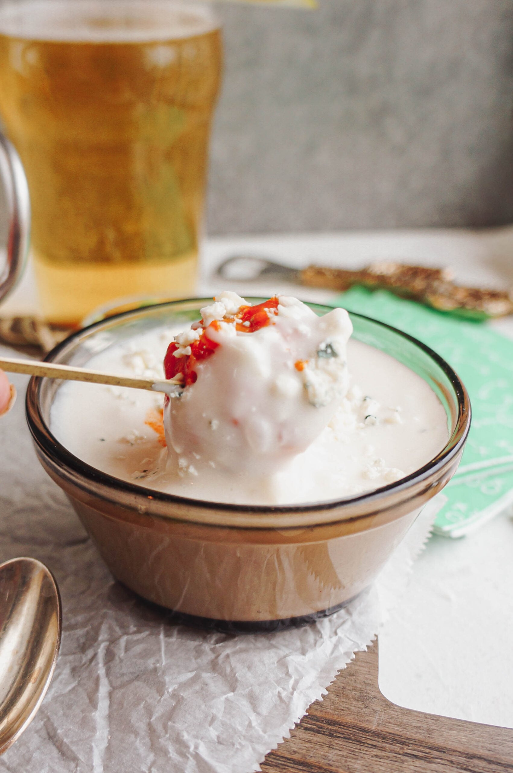 buffalo chicken meatballs Buffalo turkey meatball dipped into creamy blue cheese dressing on a skewer, with crumbled blue cheese and buffalo sauce, served alongside a cold beer for game day.