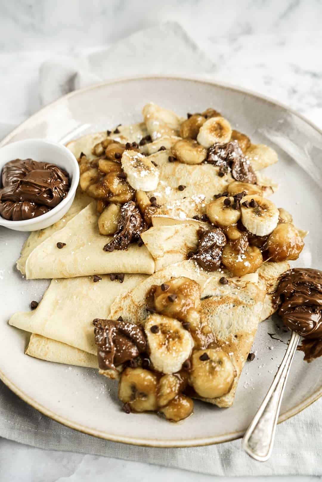 finished bananas foster nutella crepes topped with chocolate chips on platter
