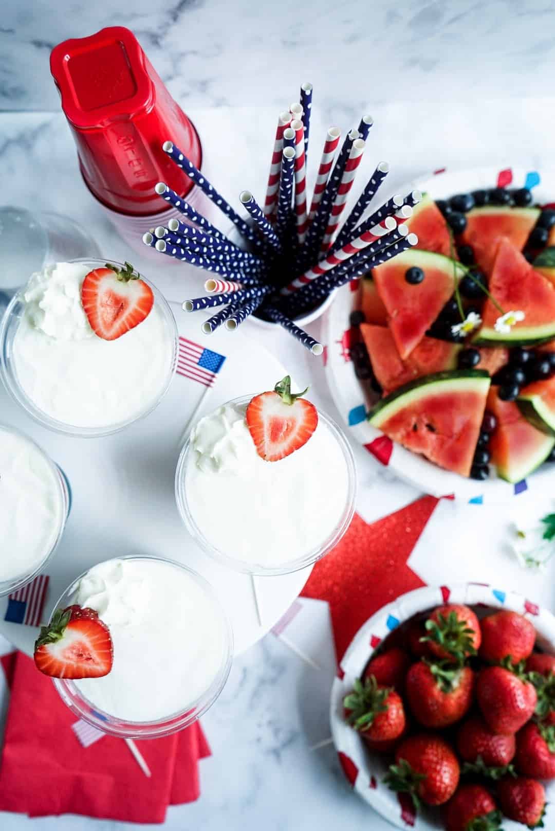 Stars and Stripes Frozen Yogurt Cups with sliced watermelon and strawberries in bowls