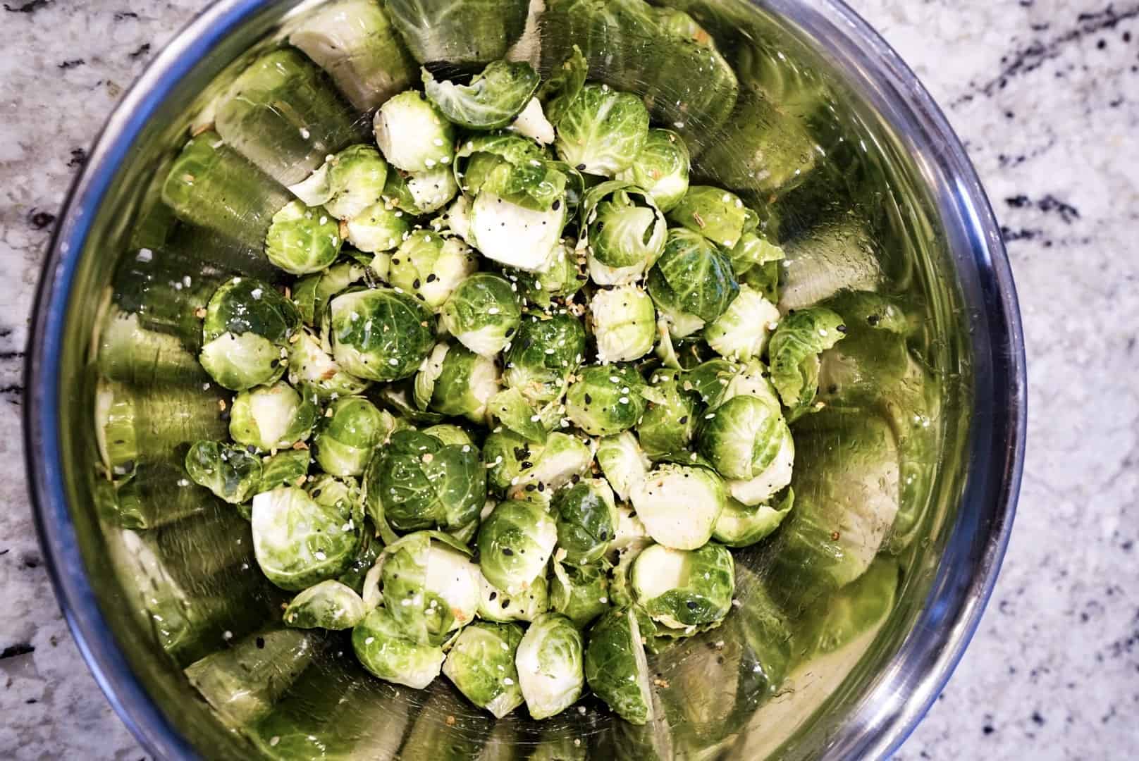 raw seasoned brussels sprouts in bowl 