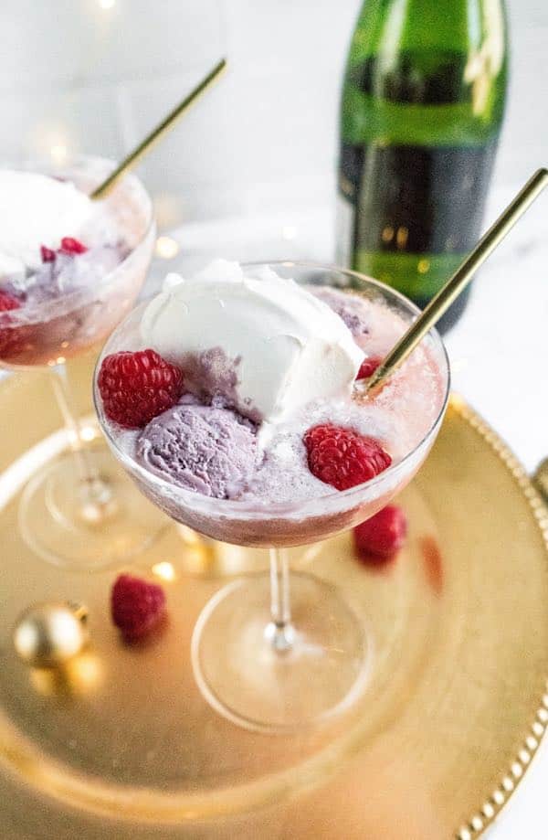 champagne floats with spoon and raspberries on serving tray