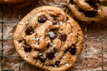 chocolate chip cookies on cooling rack and a small bowl of flaky salt