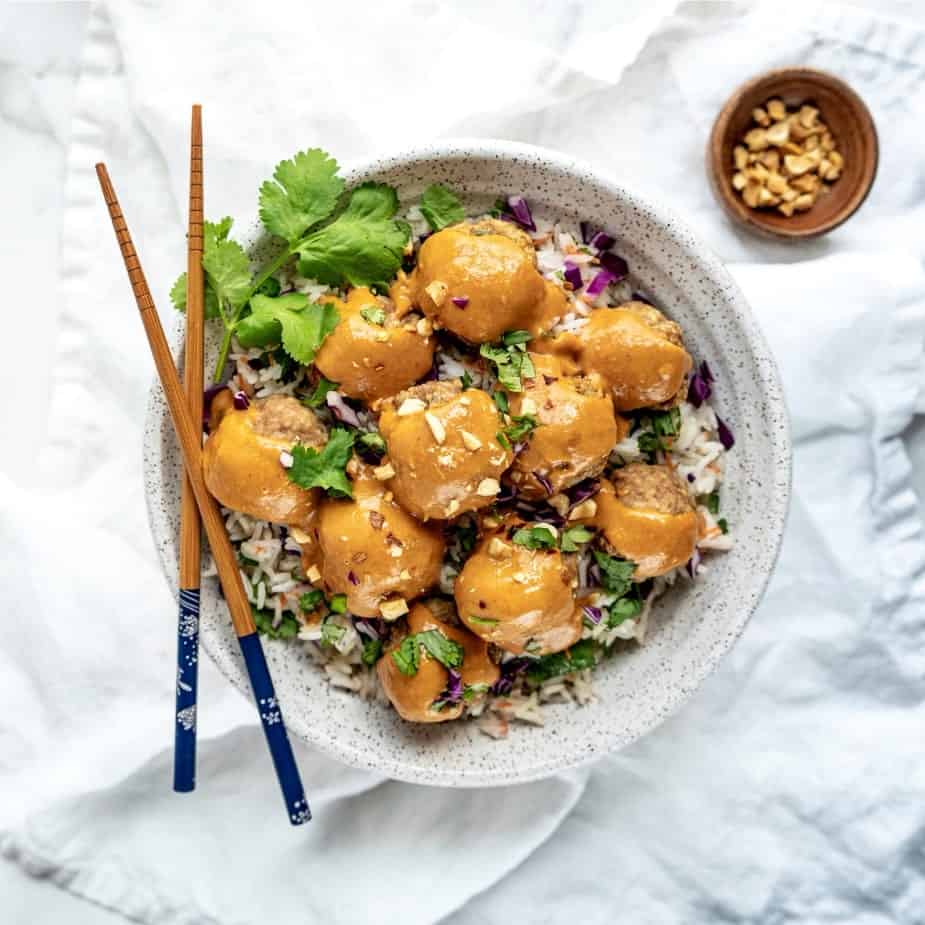 cooked asian turkey meatballs with peanut sauce and chopsticks