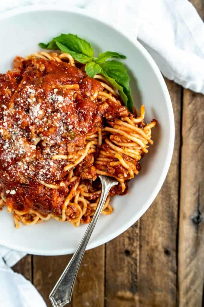 spaghetti bolognese in bowl with pasta twirled around fork