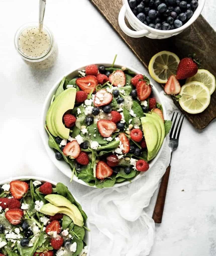 strawberry and spinach salad with fresh berries and avocado in bowl 