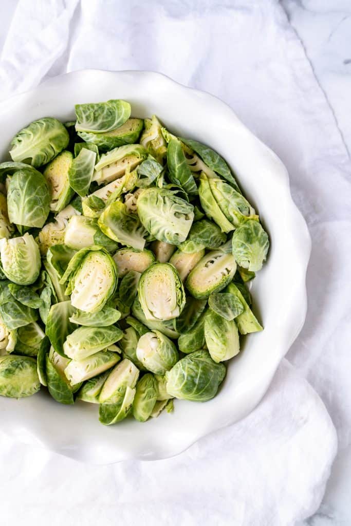 raw brussels sprouts sliced in half in baking dish