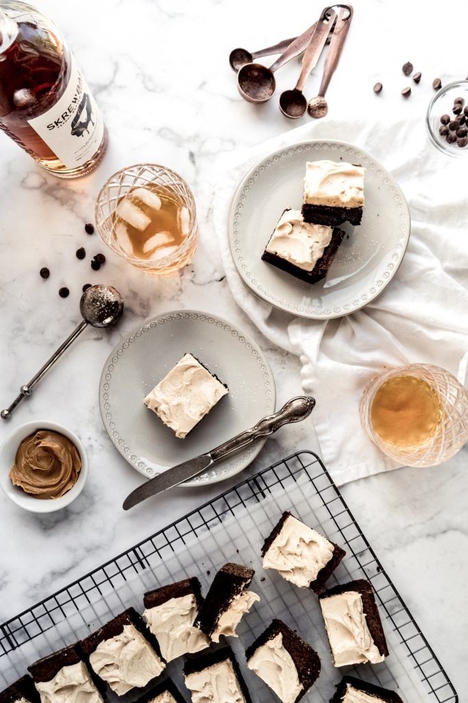 whiskey brownies on cooling rack with cut brownies on plates with whiskey in glasses