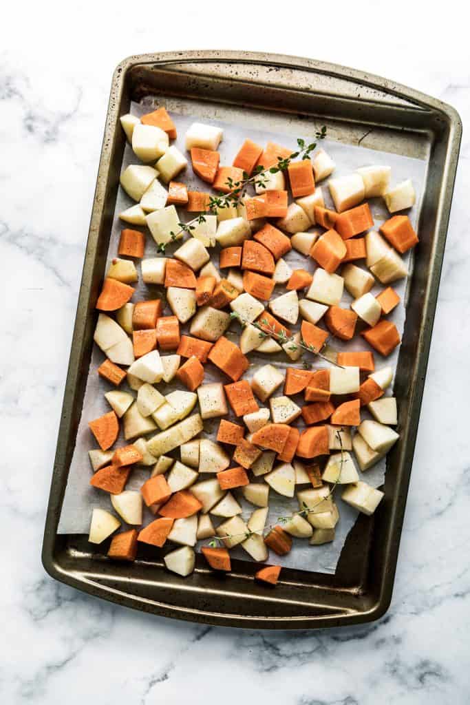 carrots and apples on roasting pan with thyme