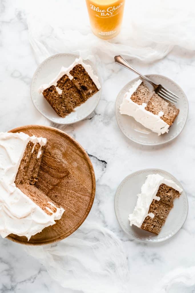 bananas foster cake on stand with three slices on plates