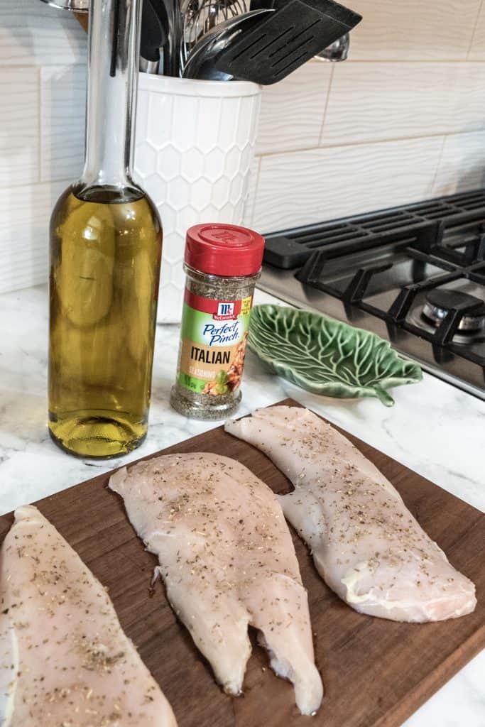 Raw chicken seasoned on cutting board and 