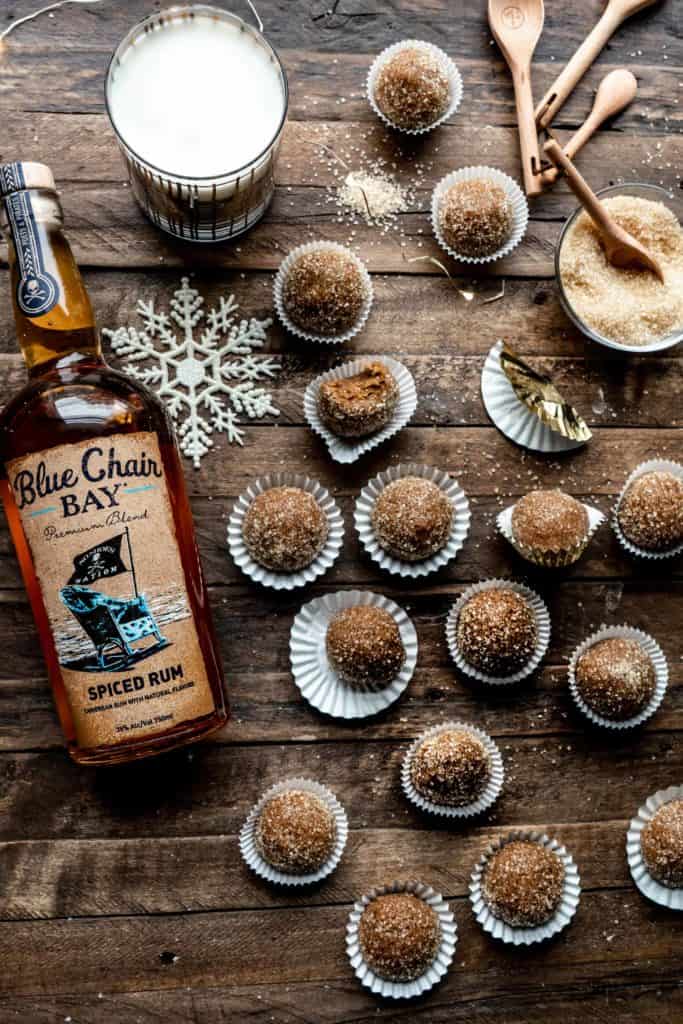 ginger spice rum balls in a dish with rum bottle behind