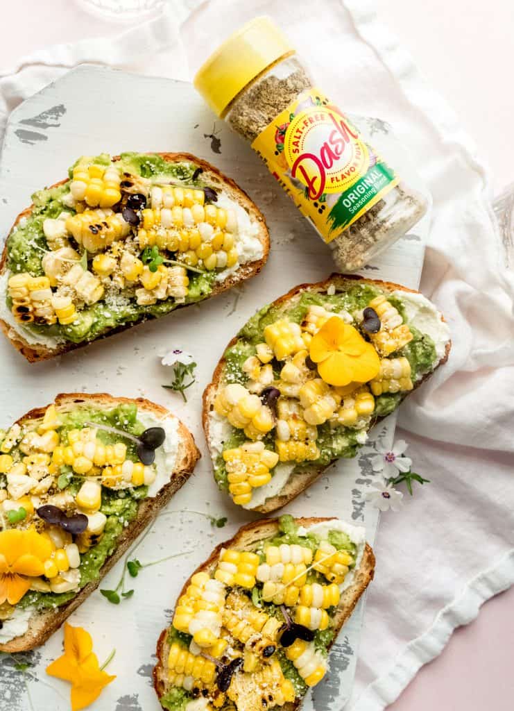 close up shot of sweet corn bruschetta on white cutting board