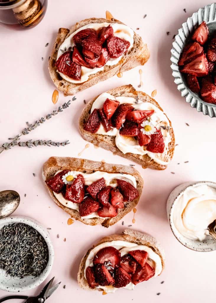roasted strawberry bruschetta on pink backdrop with sweetened ricotta in a cup 