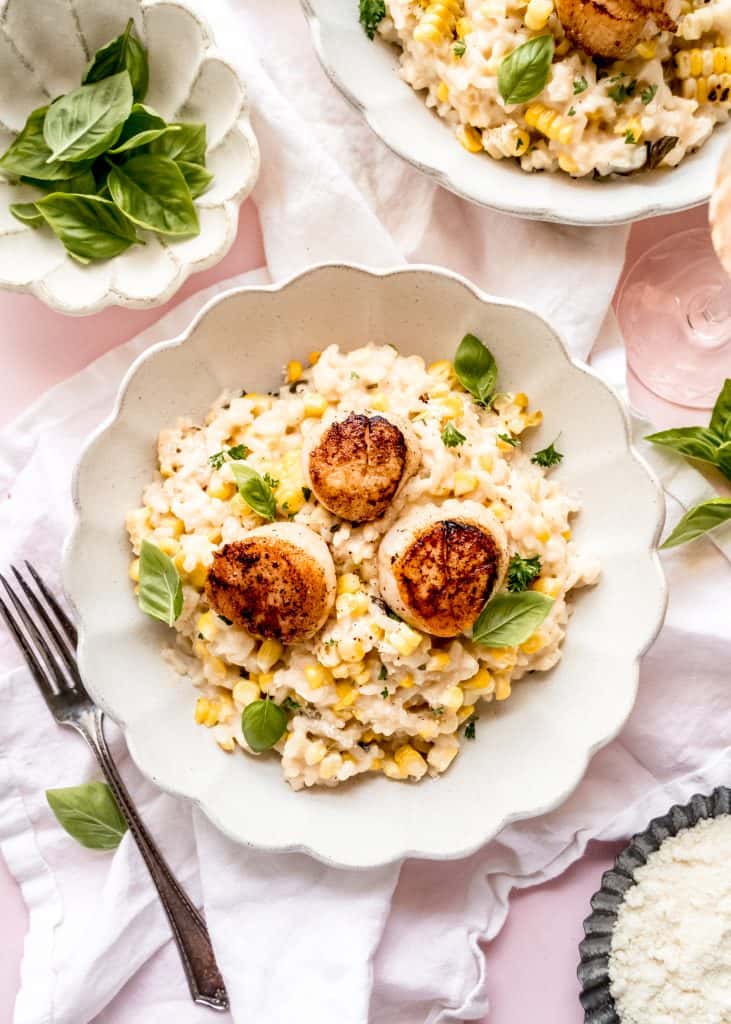 sweet corn risotto in bowl topped with seared scallops