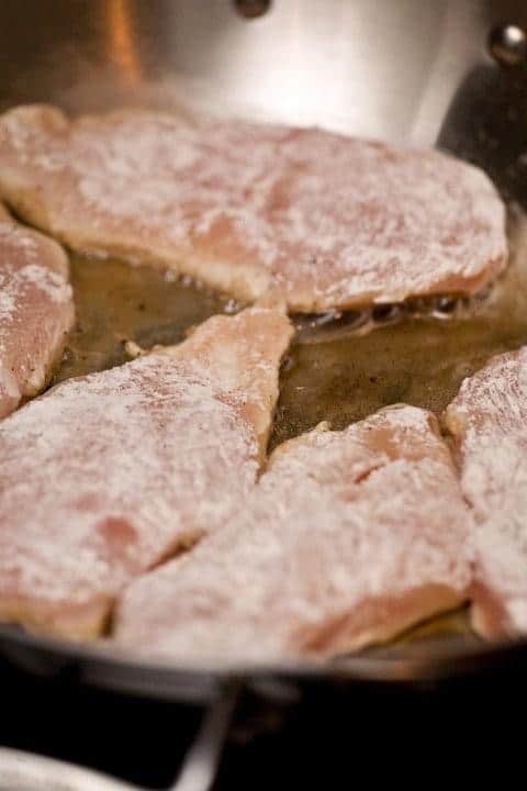 chicken breasts being cooked in skillet