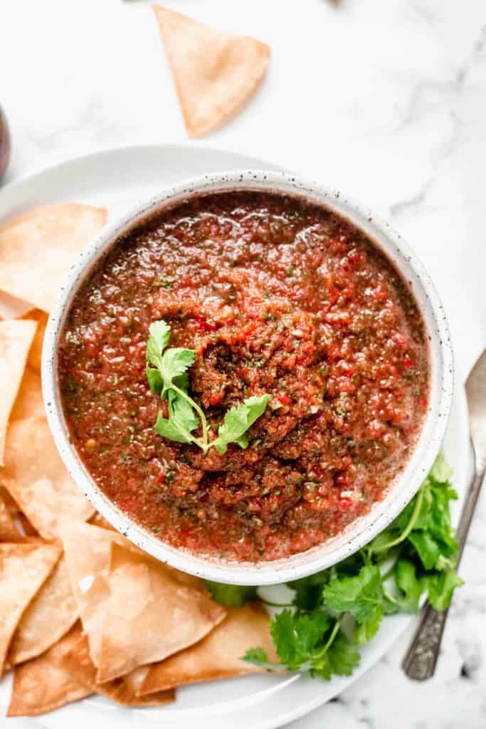 fresh tomato salsa in bowl with tortilla chips surrounding 