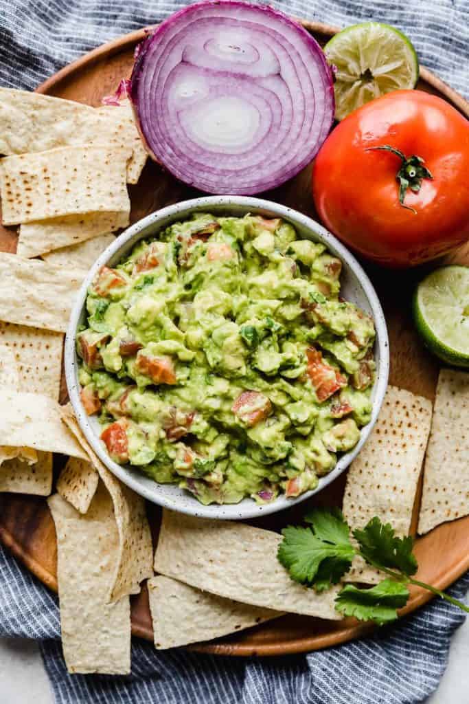 guacamole in bowl surrounded by tortilla chips 