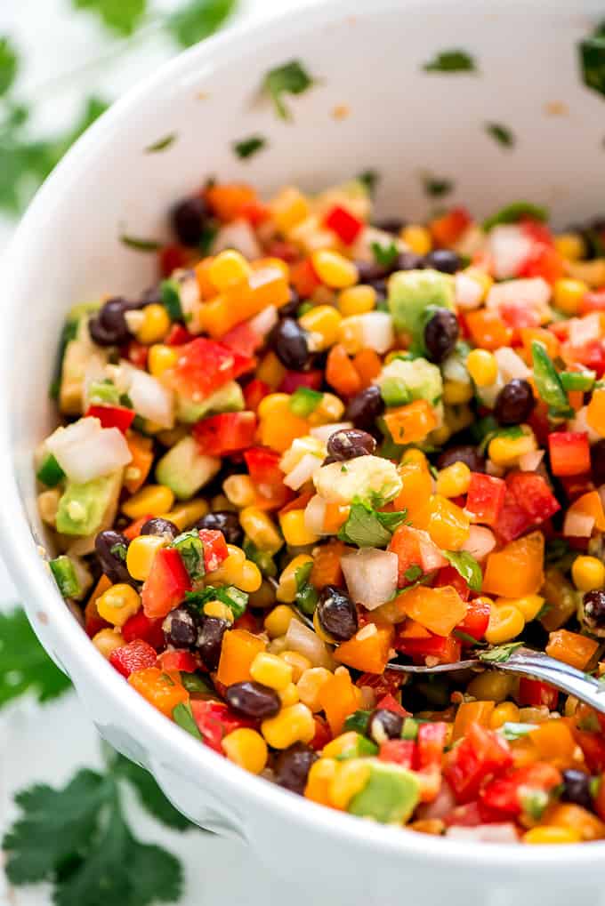 corn and black bean salsa in bowl with spoon scooping it out