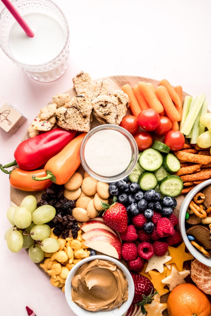 close up shot of peanut butter sandwiches, cookies and fruit on kids charcuterie board 