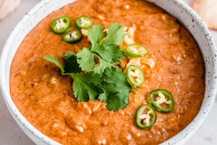 smoked queso dip in bowl garnished with cilantro and jalapenos