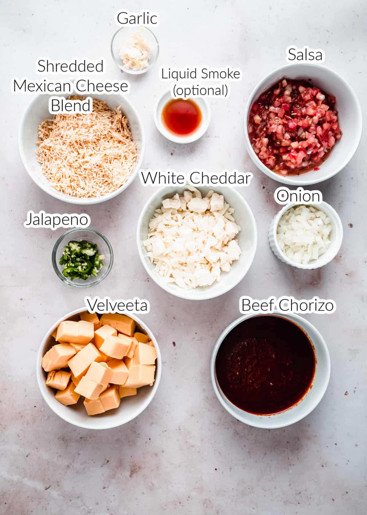 Ingredients for smoked queso dip in individual bowls