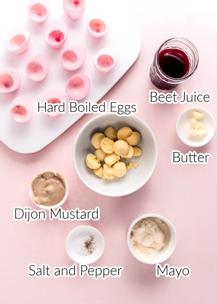ingredients for pink easter deviled eggs in bowls on pink background