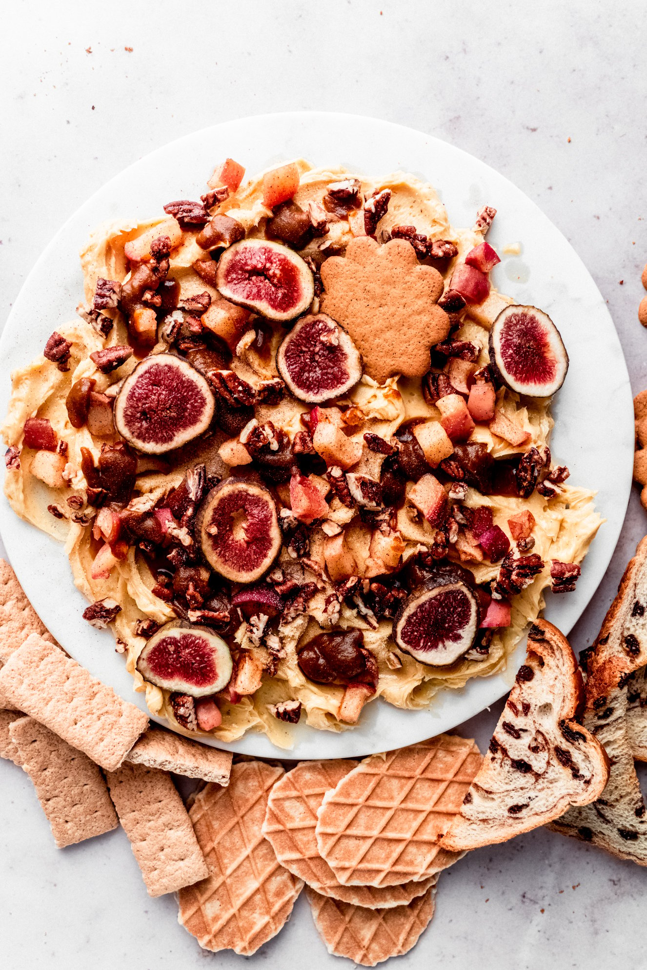 fall butter board on round marble platter surrounded by graham crackers, cinnamon raisin toast