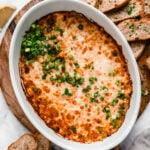crab rangoon dip in baking dish garnished with chopped green onions