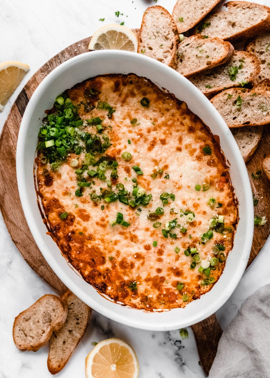 crab rangoon dip in baking dish garnished with chopped green onions