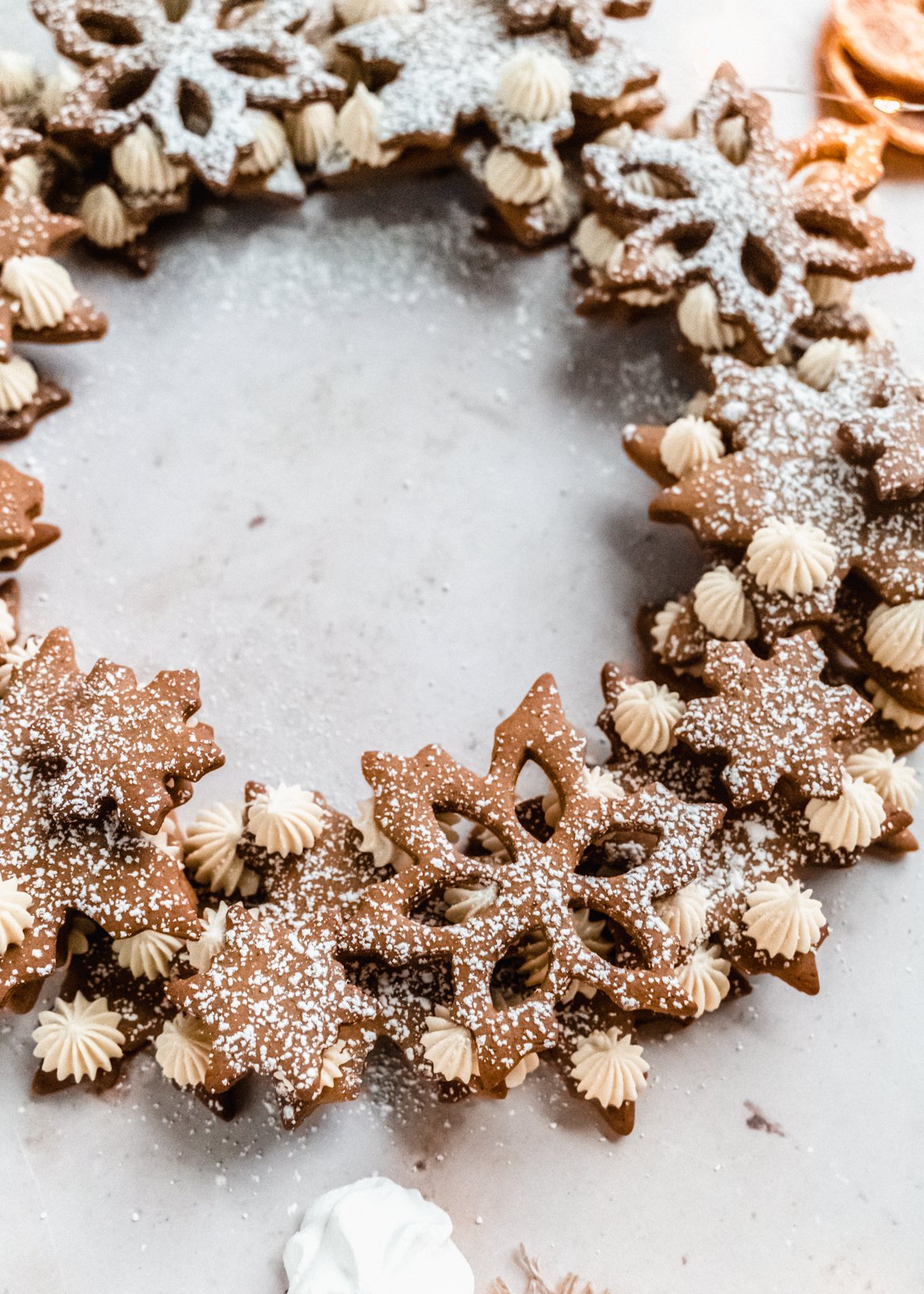 up close shot of gingerbread wreath dusted with powdered sugar