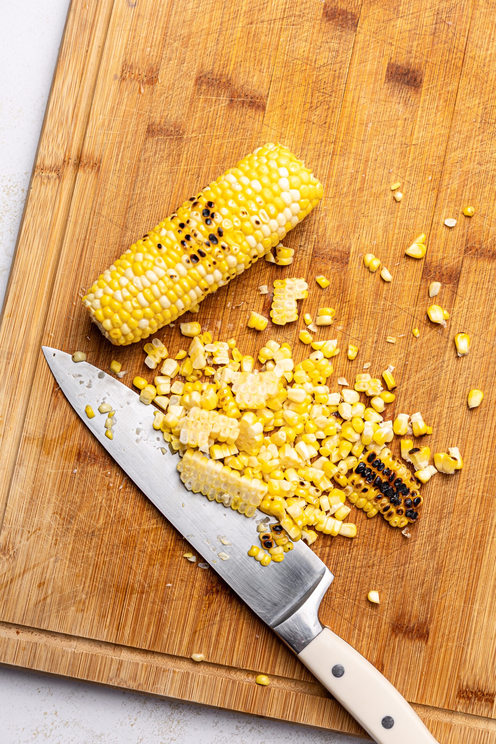 step one and two of making Corn and pineapple salsa: grilling and chopping the corn