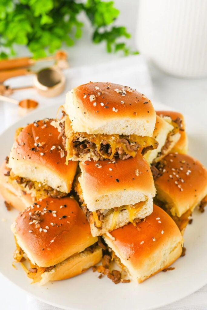Golden,+cheesy+beef+sliders+piled+on+a+plate,+showing+the+melted+cheddar+and+seasoned+tops
